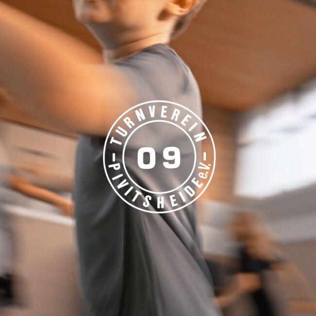 Turnender Junge vor dem Vereinslogo als Motiv einer Videoproduktion